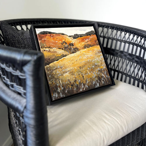 Autumn Glow painting propped on a chair showing scale and warm earthy palette