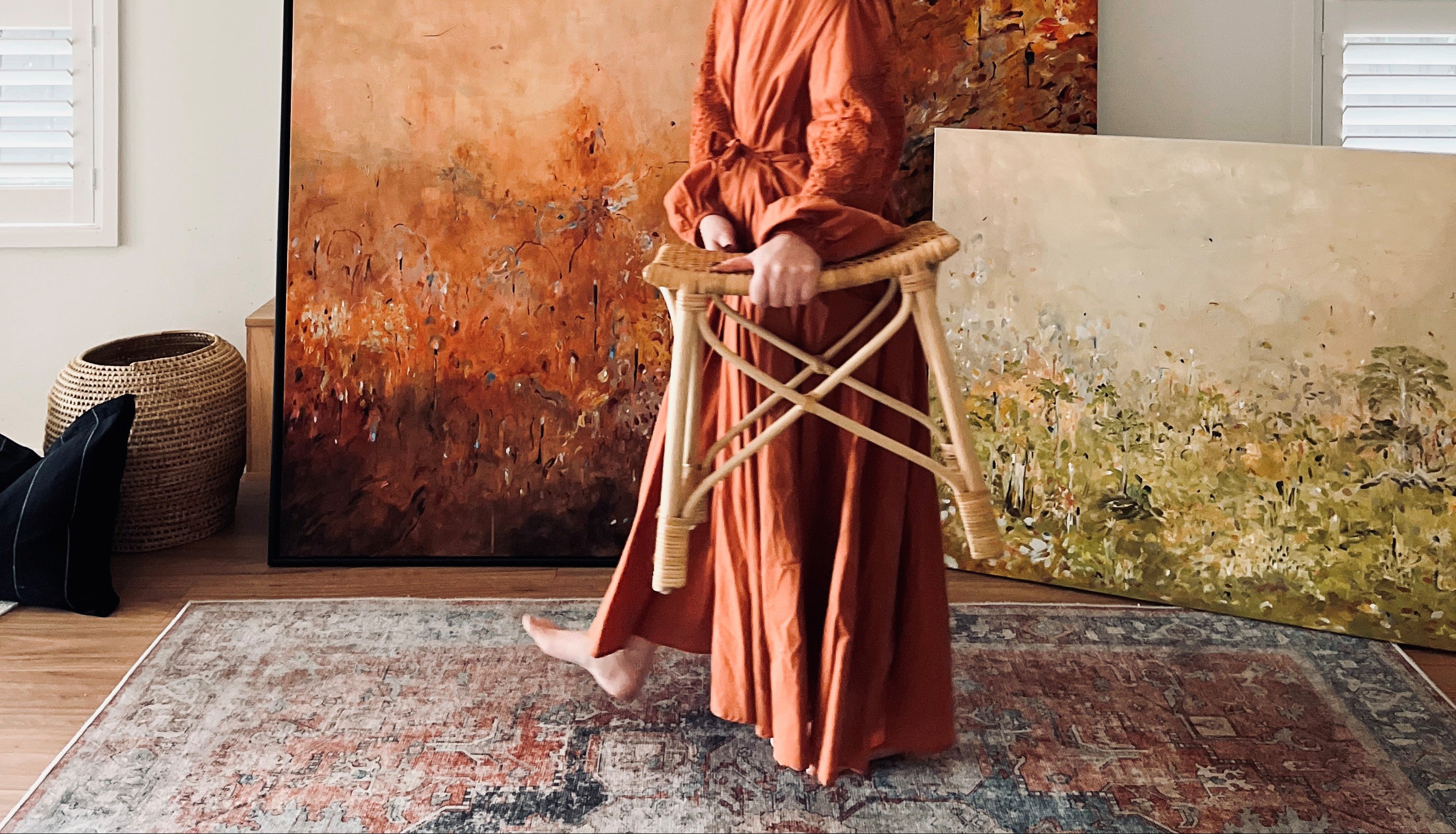 Australian abstract landscape artist Emma O'Connell standing in her studio with original acrylic painting